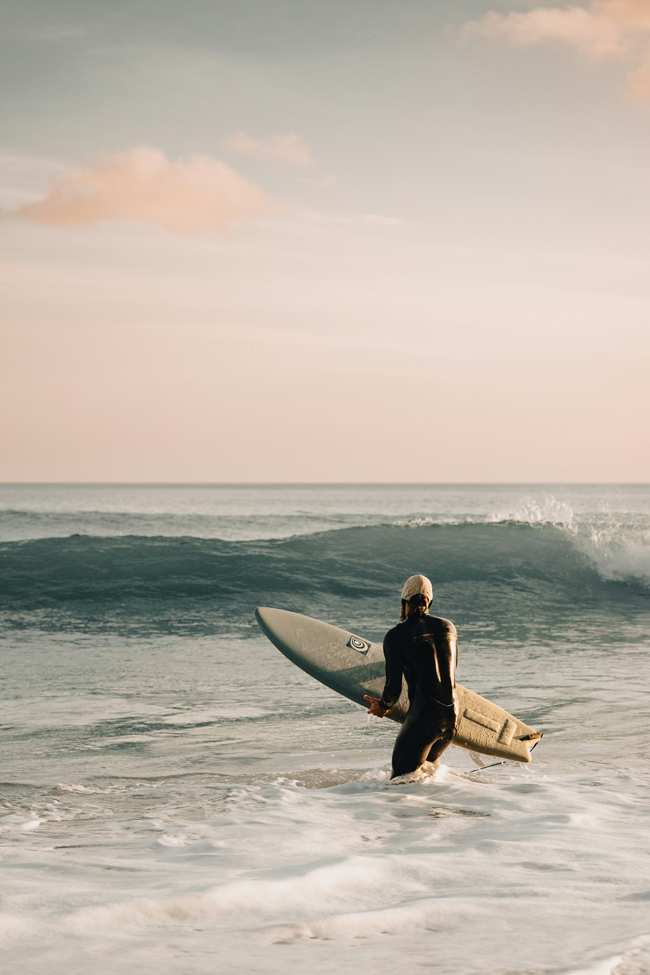 Surfer entering the water at Praia da Luz, Western Algarve