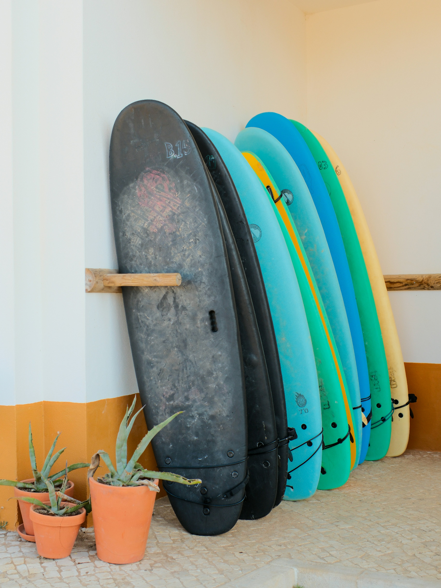 Colourful surfboards leaning against a whitewashed Algarve wall